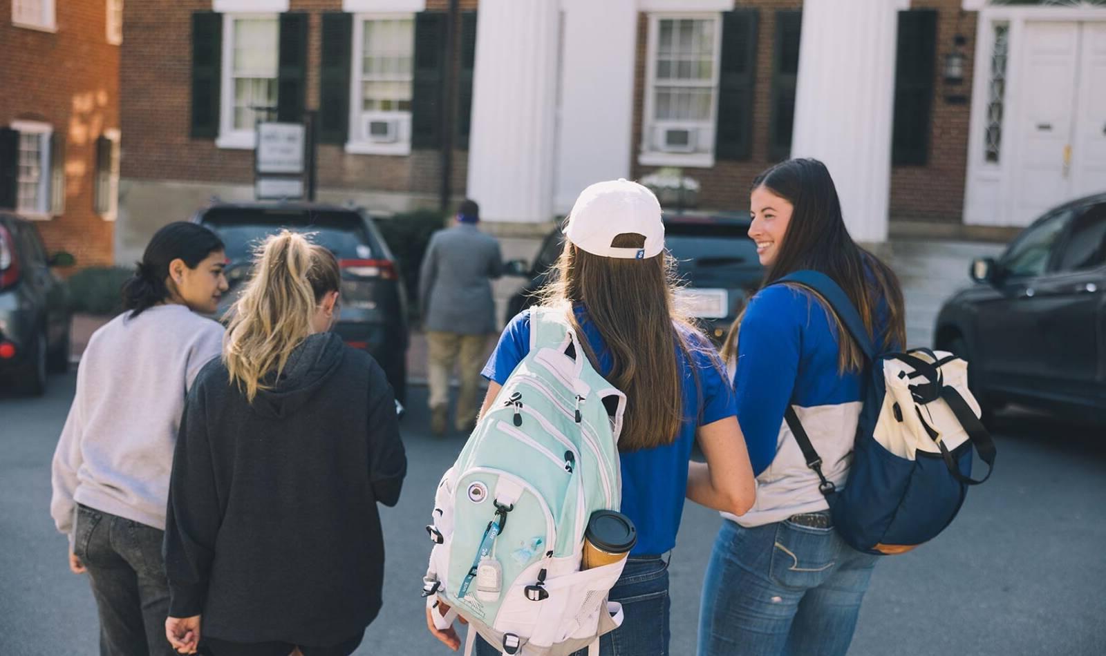 Students walking on Salem College Campus with their backpacks
