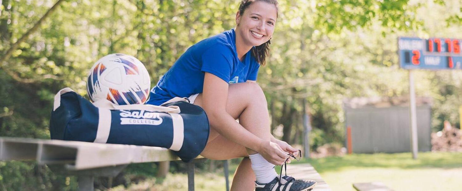Salem College soccer athlete tying her shoe