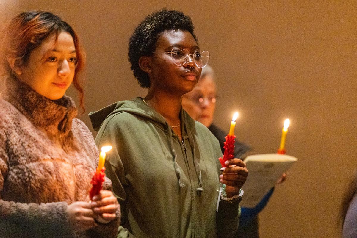 Two students holding candles at candle ceremony
